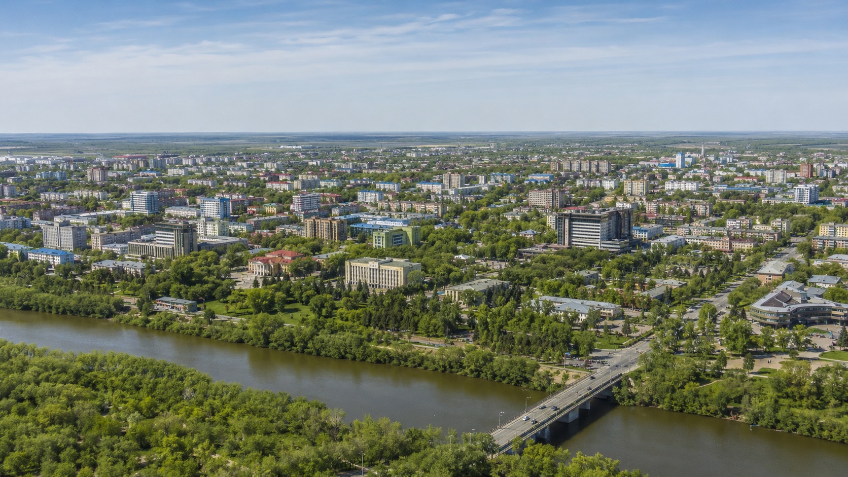 Панорама Костаная с рекой Тобол, набережной, зелёными кварталами и городской застройкой